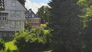 Ein gepflegter Rasen mit einem traditionellen Haus im Hintergrund.