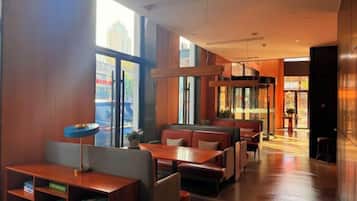 Un restaurante con cabinas y mesas, ventanas amplias y una decoración de estilo moderno.