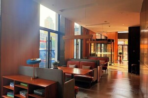 Restaurante com cabines e mesas, grandes janelas e design de interiores moderno.