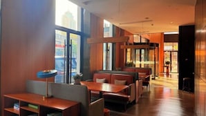 A modern restaurant interior with wooden tables and booths, large windows, and a view of the city. - Yilin International Hotel (Hefei)