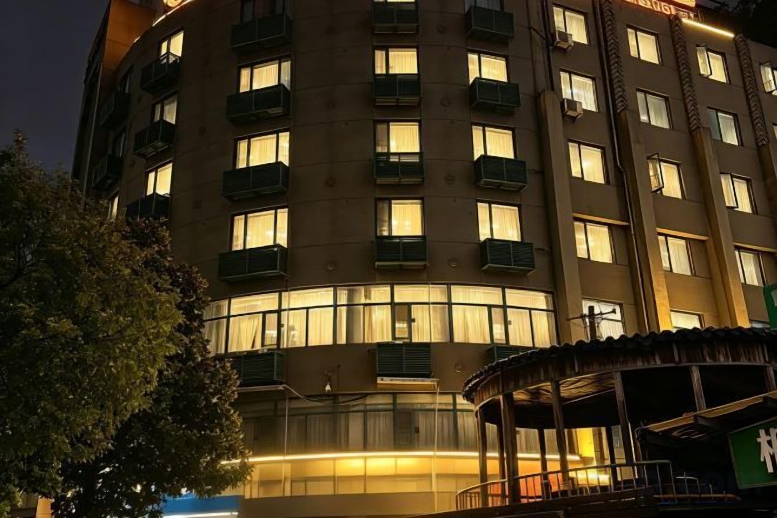 A multi-story hotel with balconies and a covered outdoor seating area.