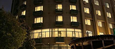 A multi-story hotel with balconies and a covered outdoor seating area.