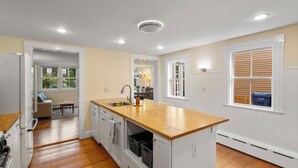 A modern kitchen with wooden countertops, white cabinetry, and a central island. - Entire 4BR 2 Bath Home l Minutes to Downtown Salem (Salem)