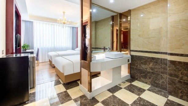 A modern hotel room with a large bed, a separate bathroom with a large mirror, and a checkered floor. - Aifeng Hotel (Yiwu Gongren North Road) (Yiwu)