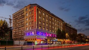 A multi-story hotel with a ground-level bar and restaurant, featuring a modern facade and illuminated signage. - Aifeng Hotel (Yiwu Gongren North Road) (Yiwu)