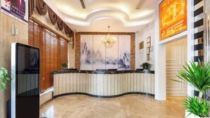 A hotel reception area with a curved reception desk, a large wall painting, and a chandelier. - Aifeng Hotel (Yiwu Gongren North Road) (Yiwu)