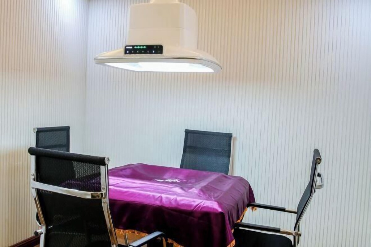 A room with a bed, a table, and two chairs.