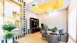 A modern hotel lobby with a dining area, a fireplace, and a large painting on the wall. - Aifeng Hotel (Yiwu Gongren North Road) (Yiwu)