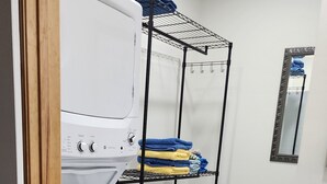 A laundry room with a washing machine, a drying rack, and a bench. - Hidden Gem in Historic Downtown Moultrie!  (Moultrie)