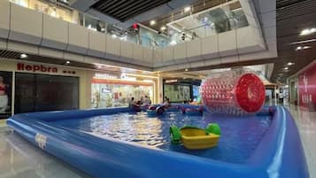An indoor water play area with inflatable toys and a large red ball.