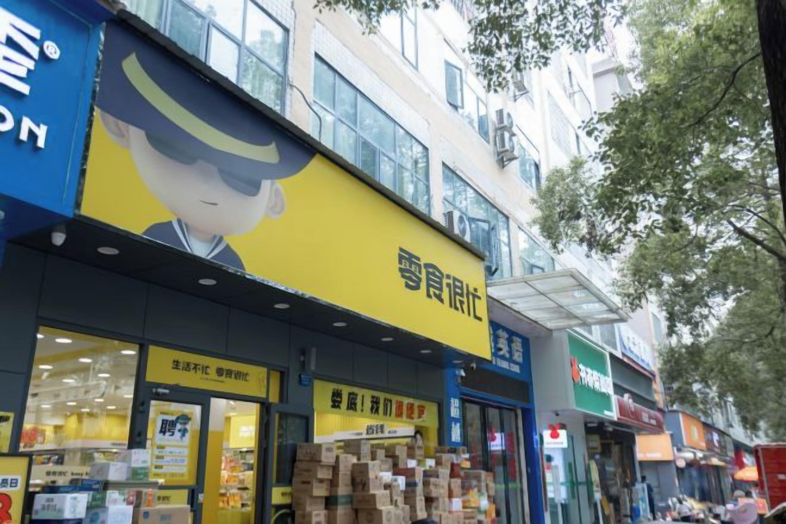 A storefront with a yellow sign and multiple packages stacked outside.