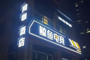 Un edificio con señalización iluminada que indica un hotel y un restaurante de mariscos.