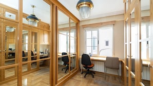 A spacious room with wooden flooring, large windows, and a desk area with office chairs. - PUSHE Granada Plaza Menorca Art & Tradition (Granada)
