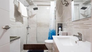A modern bathroom with a shower, toilet, and sink. - Casa de Sol (Fuengirola) (Fuengirola)
