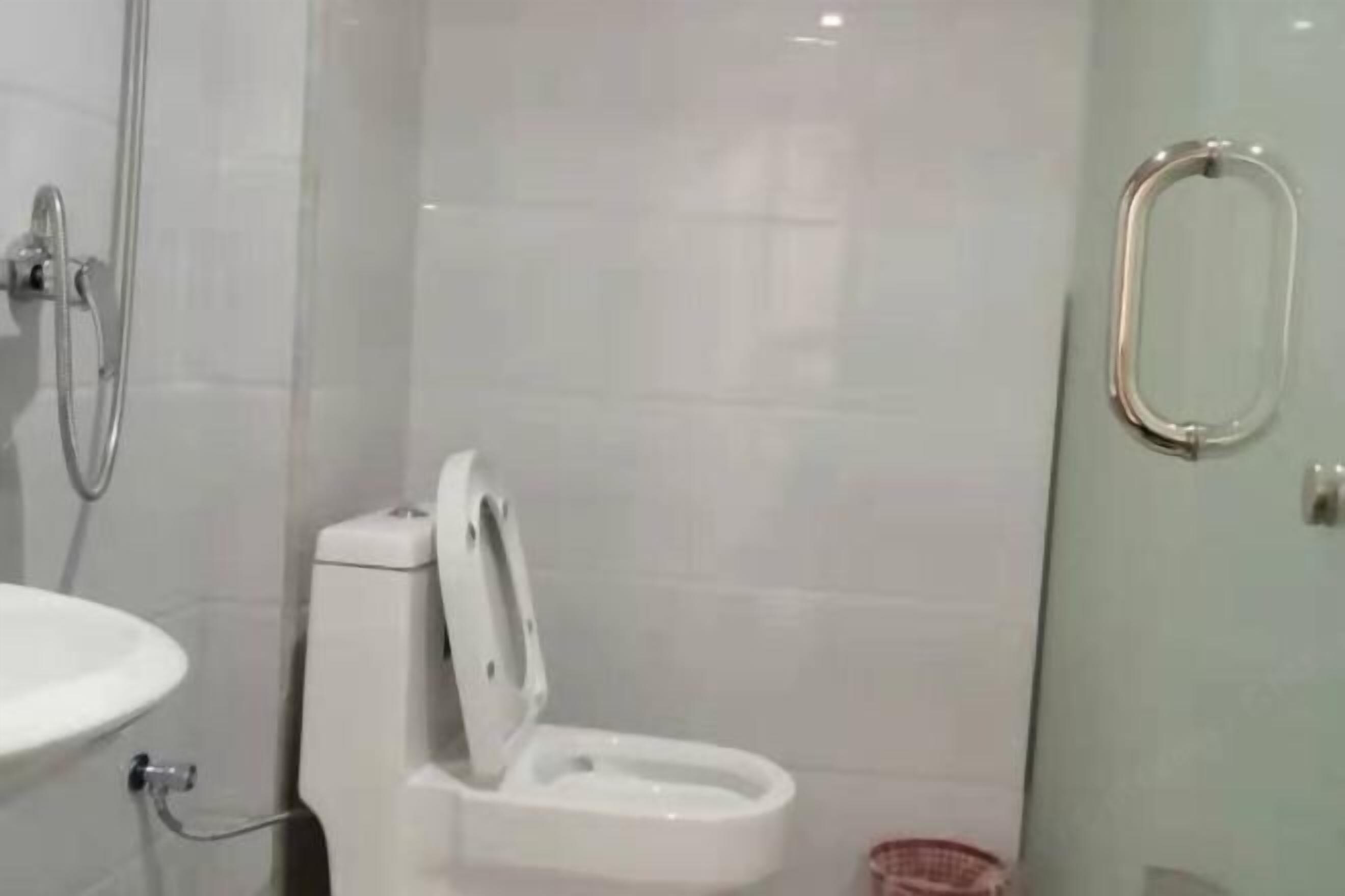 Un baño con inodoro, lavamanos y zona de ducha.