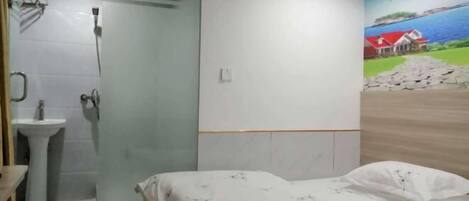 A bedroom with a bed, a shower, a sink, and a mural on the wall.