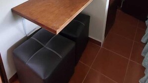 A small room with a wooden table and a black cushioned bench. - Villa Lorena Casa de Huespedes (San Salvador)