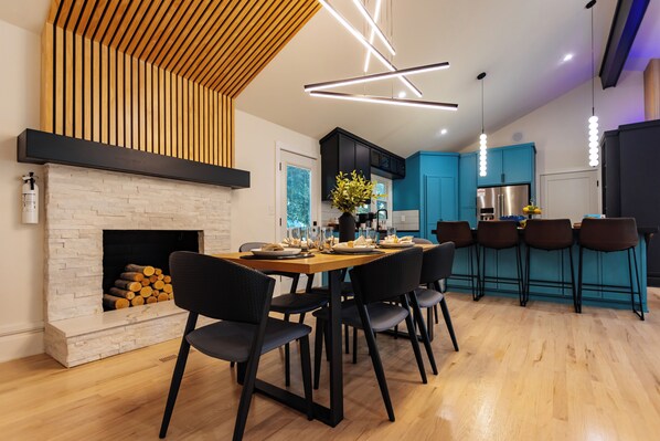 Een moderne keuken met een ingebouwde open haard, houten plafond en blauwe kastjes.