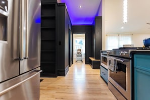 Eine moderne Küche mit Edelstahlgeräten, Holzboden und einem blauen Schrank.