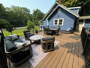 A deck with outdoor furniture, including a sofa, chairs, and a table.