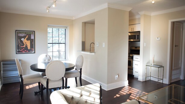 A modern living room with a dining area, a glass coffee table, and a sofa.