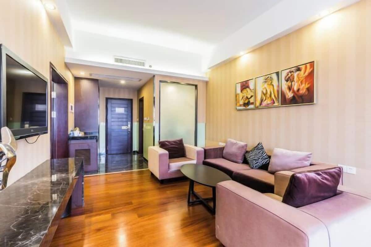 A modern hotel lobby with a marble reception desk, plush seating, and artwork on the walls.