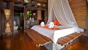 A bed with a canopy, wooden headboard, and a bench at the foot of the bed. - View Point Resort Koh Tao (Koh Tao)