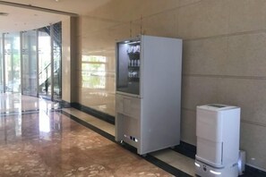 A hallway with a refrigerator and a water dispenser. - Jinxin Huayuan Hotel (Shantou)