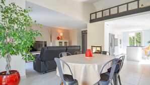 A modern living room with a dining area, a sofa, and a TV. - Cozy home in Marguerittes (Marguerittes)