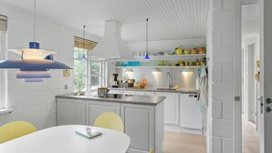 A modern kitchen with white cabinetry, a central island, and pendant lighting.