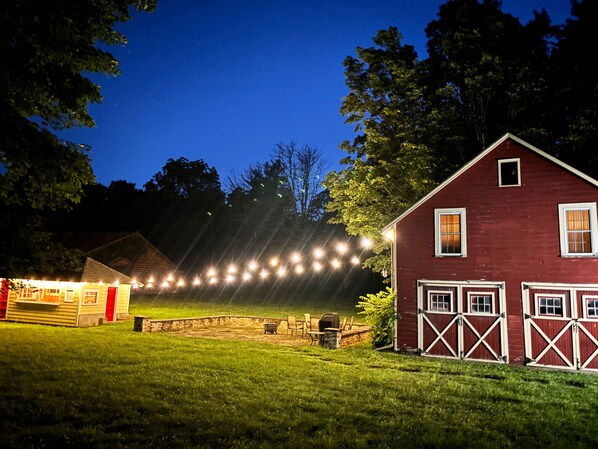 A red barn with white trim and a stone wall in the foreground.