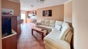 A living room with a sofa, a coffee table, and a TV on a stand. - Awesome apartment in Medulin with WiFi (Medulin)