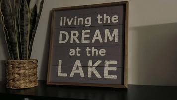 Ein Schild an einer Wand mit dem Text 'living the DREAM at the LAKE'.