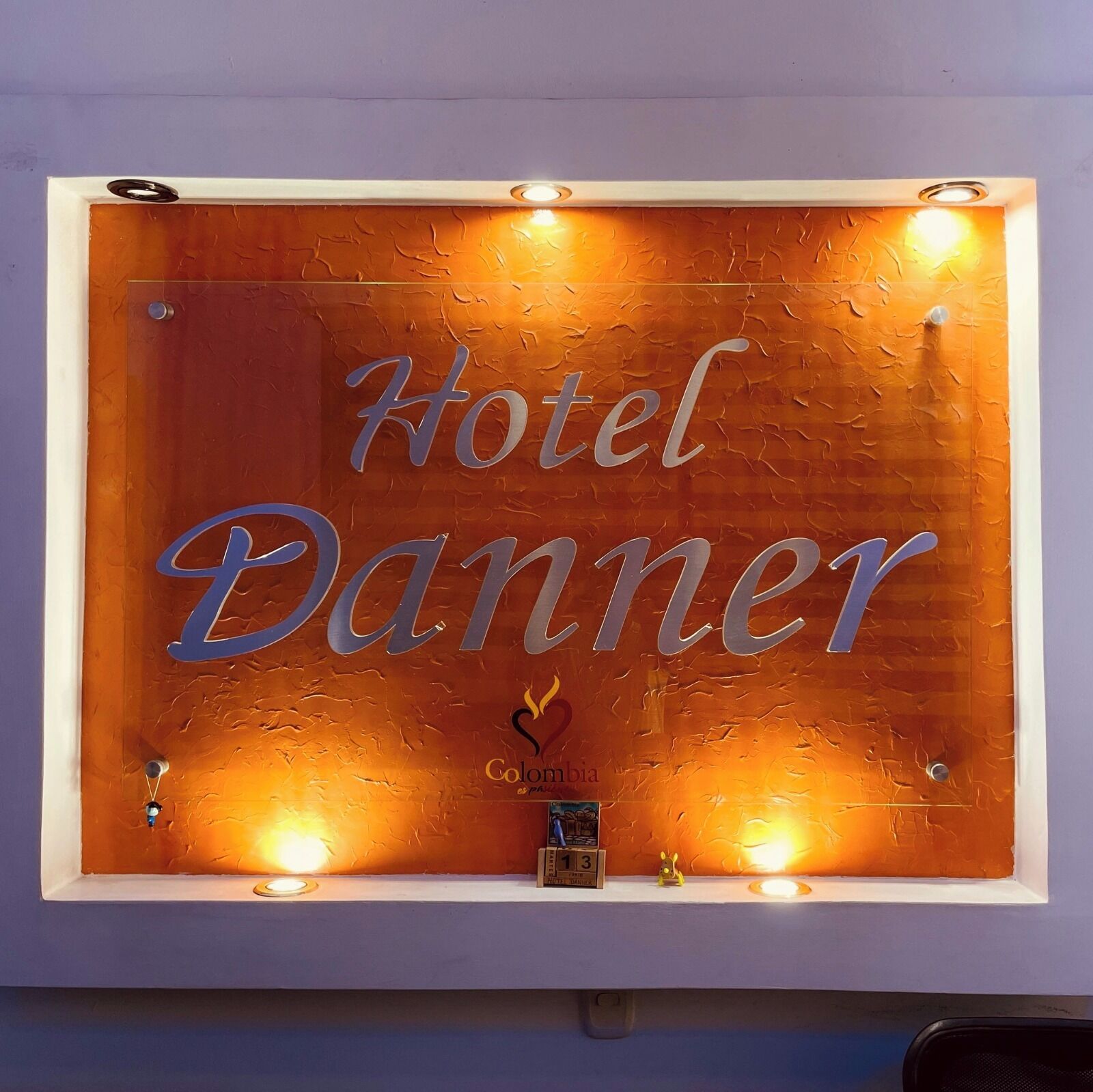 A Hotel Danner sign with a rustic wooden background and illuminated letters.
