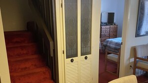 Una scala che conduce a un pianerottolo con una porta dotata di vetri smerigliati.