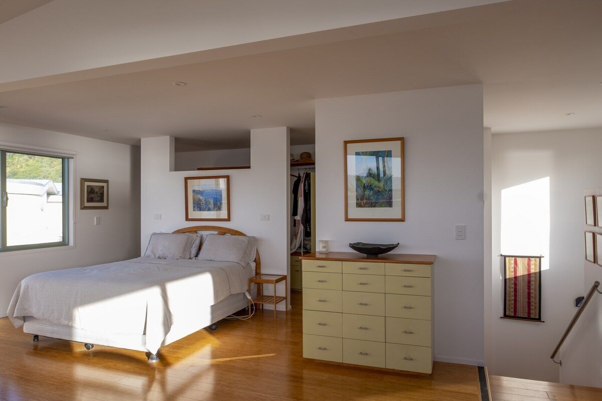 A bedroom with a bed, a dresser, and a window.