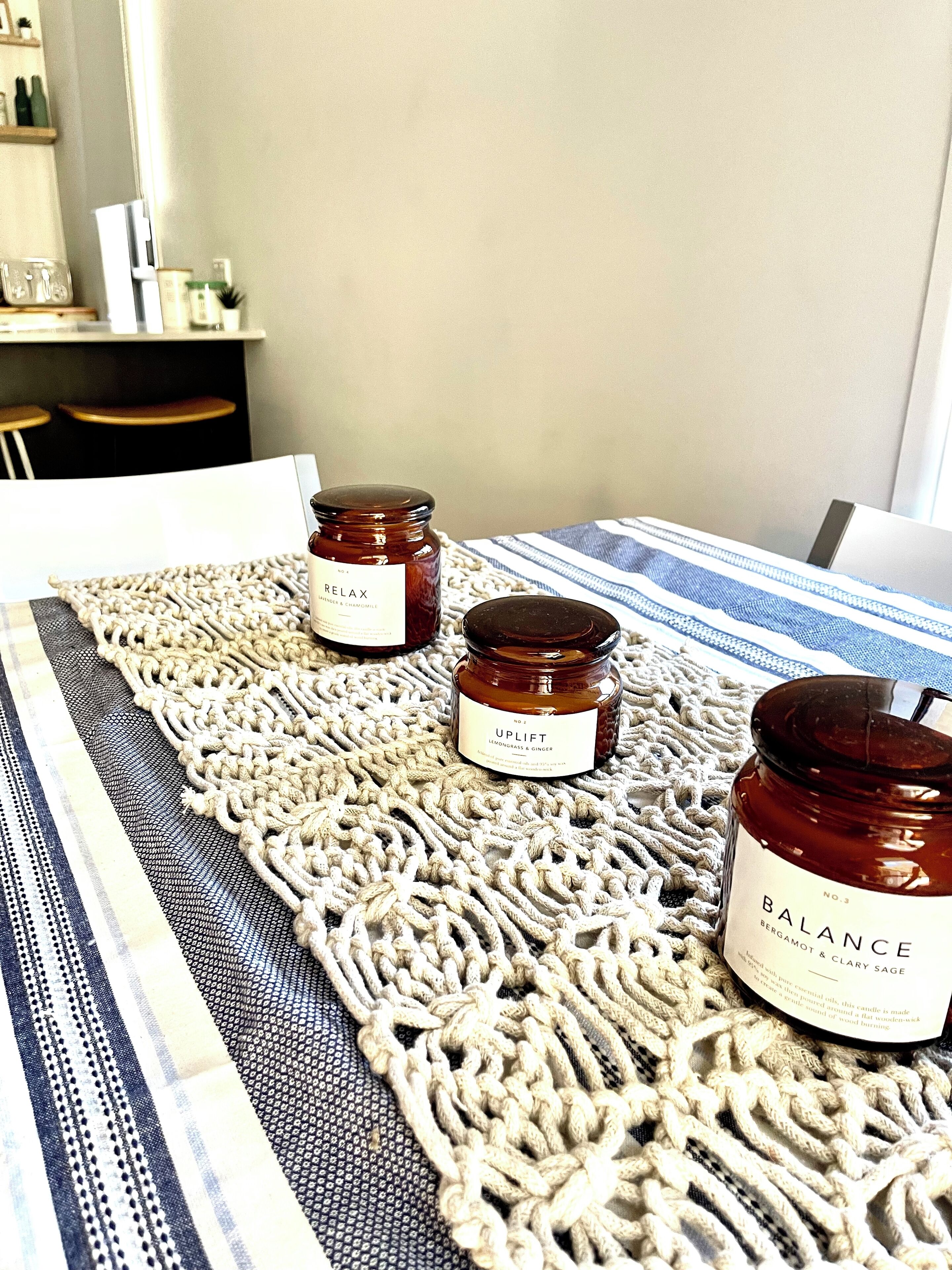 A table with three candles on a woven placemat.