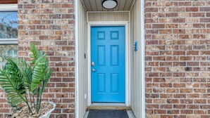 A blue door with a doormat and a potted plant beside it. - Stylish Haven NEW Walk to the Ocean, Smart TVs, Wifi (North Myrtle Beach)