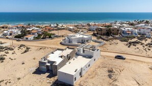 A coastal residential area with modern houses, a sandy beach, and the ocean in the background. - Spacious 4-bedroom house in marvelous Las Conchas with AC, WiFi (Las conchas)