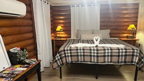 A cozy room with a bed, two bedside lamps, a wooden headboard, a small table with magazines, and a rug. - Private couples retreat/pet friendly/early checkin (Pigeon Forge)