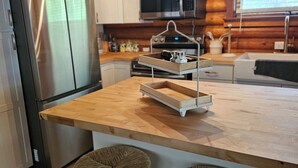 A modern kitchen with a wooden island, stainless steel appliances, and a chandelier. - Private couples retreat/pet friendly/early checkin (Pigeon Forge)