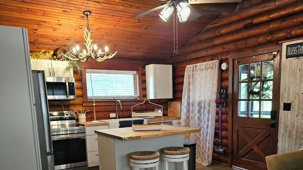 A log cabin interior with a kitchen, dining area, and a cozy living space. - Private couples retreat/pet friendly/early checkin (Pigeon Forge)