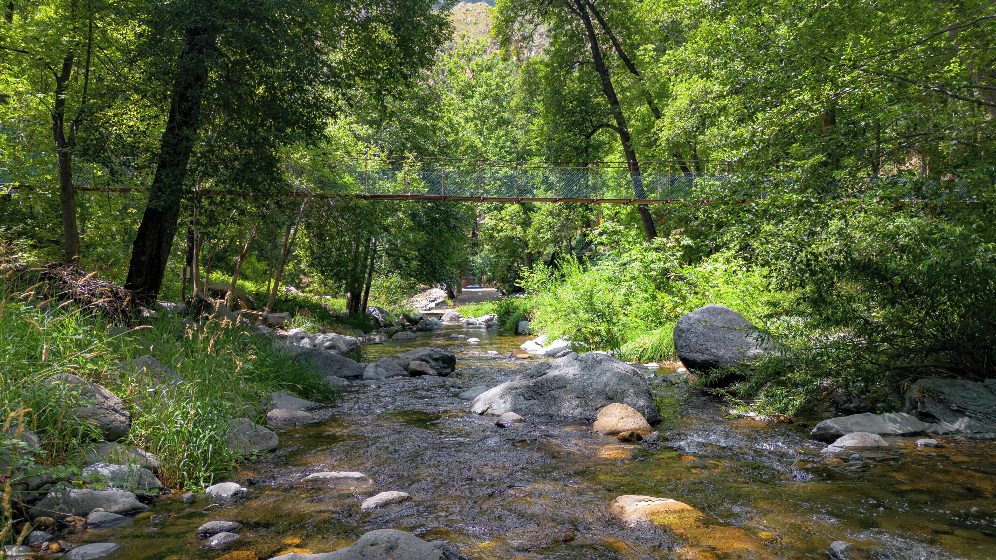 Un cadre naturel en plein air, avec un ruisseau, des rochers et une végétation luxuriante.
