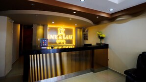 Un comptoir d’accueil d’hôtel au design moderne, comprenant un espace d’accueil, un écran numérique et un bureau d’accueil.