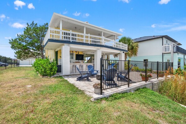 A two-story house with a covered patio and outdoor seating area.