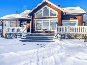 Une cabane en rondins avec des fondations en pierre, un revêtement extérieur en bois et un balcon.