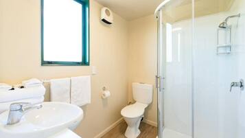 A bathroom with a sink, toilet, and glass shower enclosure.