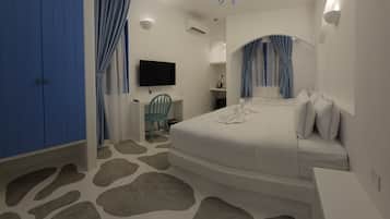 Habitación de hotel con cama, escritorio, silla, televisor y candelabro.