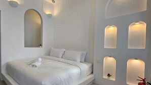 Une chambre à coucher moderne avec un grand lit, des appliques murales intégrées et un extincteur.