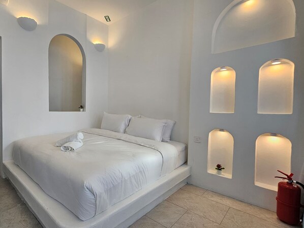 Une chambre à coucher moderne avec un grand lit, des appliques murales intégrées et un extincteur.
